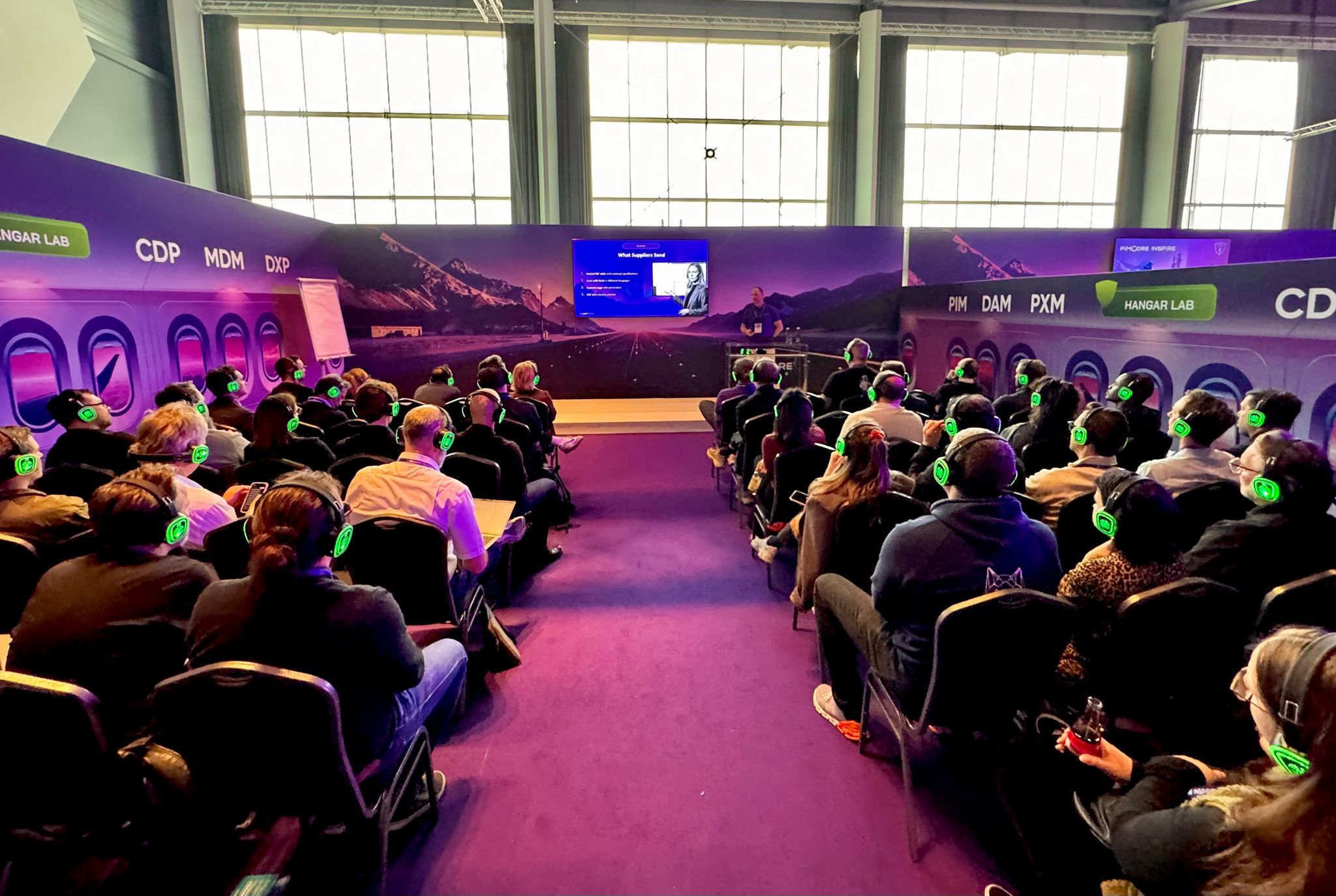 Audience wearing headphones at the openProd masterclass in the Hangar Lab at Pimcore Inspire 2026